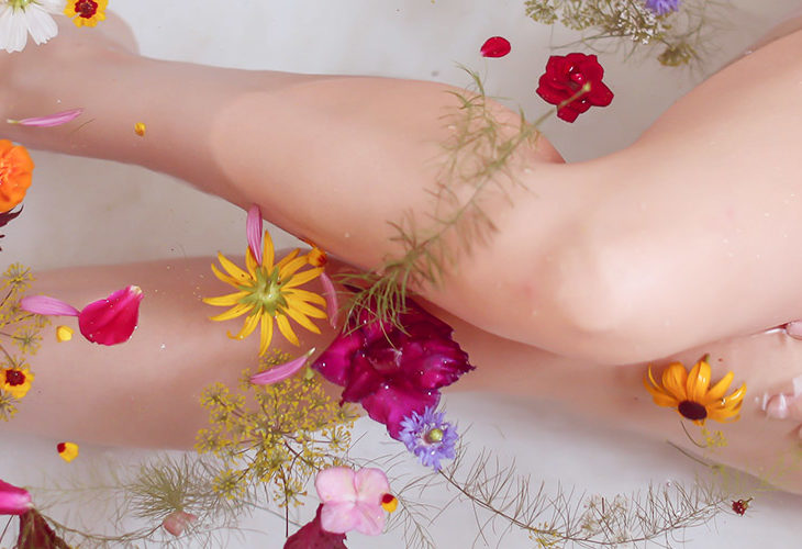 Woman in bath with flower petals