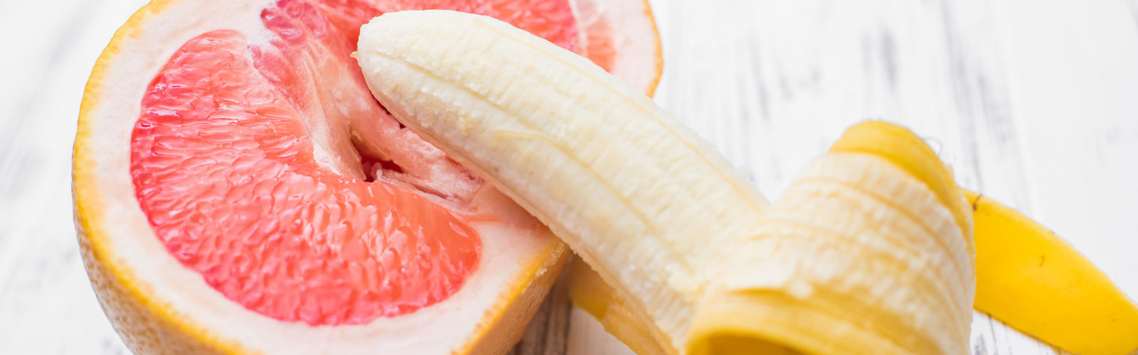 Banana over citrus fruit cut in half