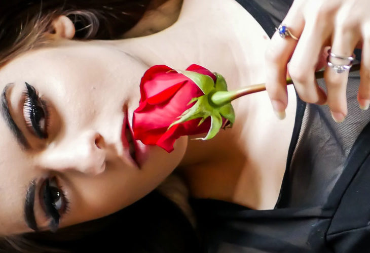 Woman holding rose against face