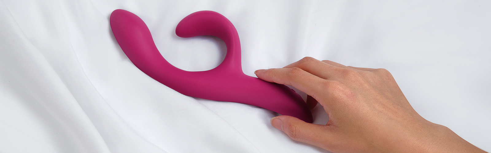 Holding a sex toy in bed