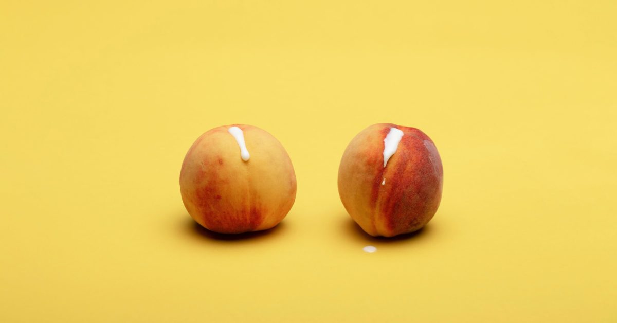 Two peaches on yellow background