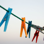 Image of Pegs clipped to a clothesline.