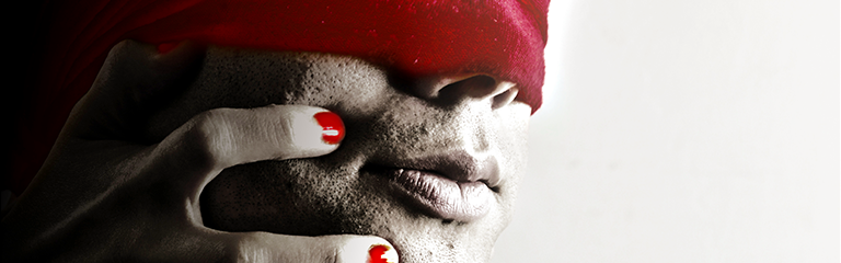 A masculine face, eyes covered by a red blindfold, is gripped by a hand with red painted nails