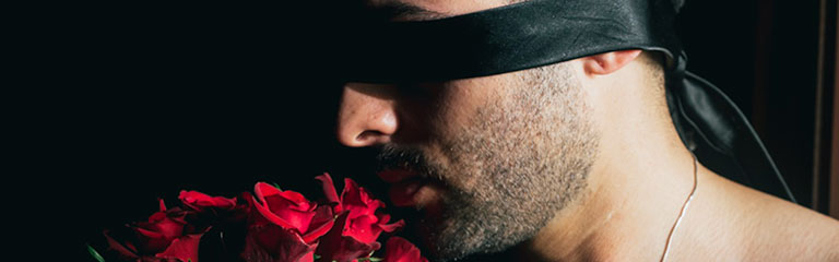A man is bound with a necktie covering his eyes as a makeshift blindfold