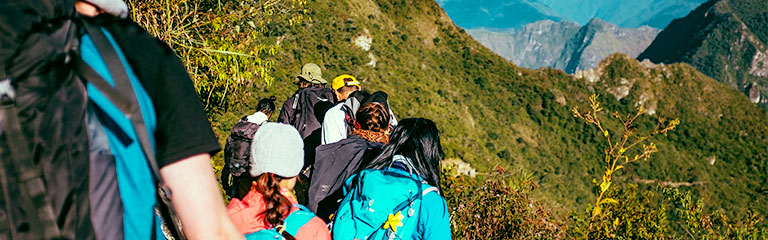 A group of friends hike along a mountain trail