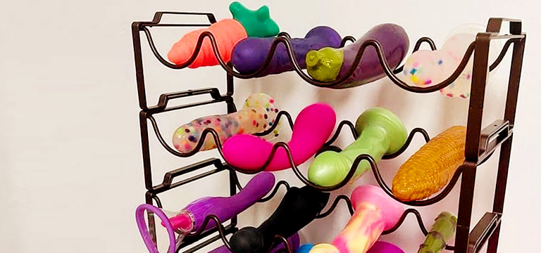 A range of dildos and other sex toys, stored in a wine rack. 