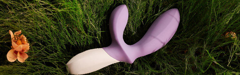 The Lelo Loki Wave 2 lies in the grass. This sex toy for men is a very powerful prostate massager.