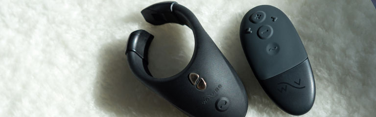 A Wevibe Bond vibrating cock ring and remote. The ring shows it's adjustable, quick release band, which opens at the base making it easy to get on and off!
