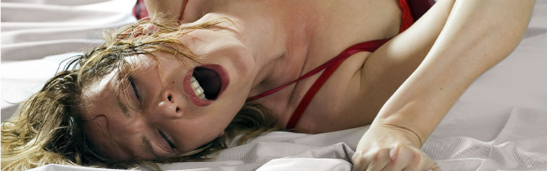 A woman clutches the sheets in the throes of ecstasy. Clitoral and vulva pleasure are key to a good orgasm - but there